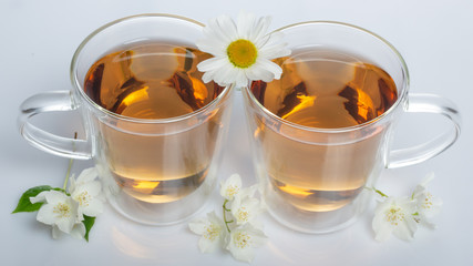 green tea with jasmine in a transparent glass thermomug on a white background
