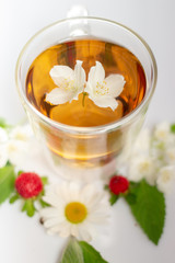 green tea with jasmine in a transparent glass thermomug on a white background