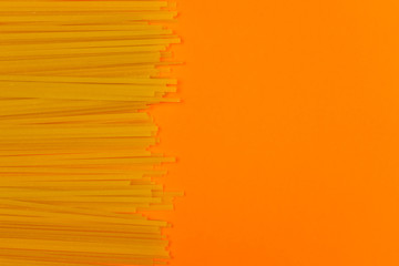 Pasta noodles on orange background