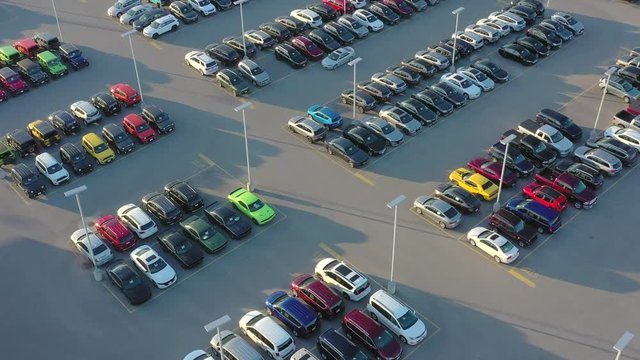New cars and trucks for sale, large automobile dealership in Springtime, aerial view.