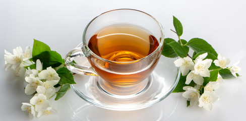 green tea with jasmine in a transparent glass thermomug on a white background