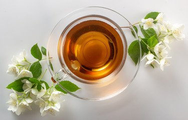 green tea with jasmine in a transparent glass thermomug on a white background