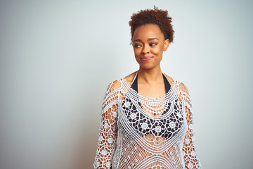 Young african american woman with afro hair wearing a bikini over white isolated background smiling looking to the side and staring away thinking.