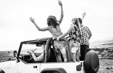 Group of friends driving off road convertible car during roadtrip - Happy travel people having fun in vacation - Friendship, transportation and youth lifestyle holidays concept © Alessandro Biascioli