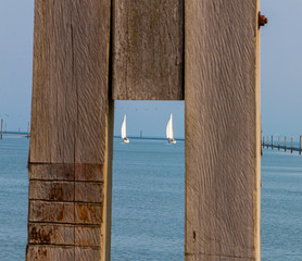 Segelboote durch zwei Holzpfähle