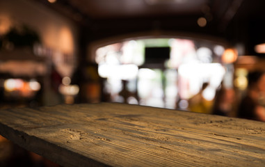 Wood table top with reflect on blur of lighting in night cafe