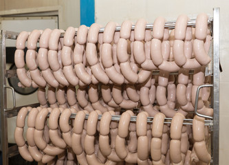 Raw sausages on racks