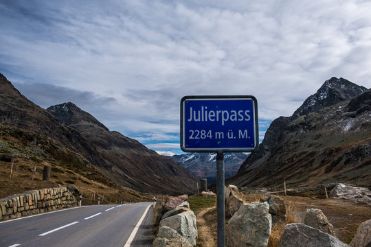 Road in autumn leading over the Julierpass Switzerland, cloudy sky