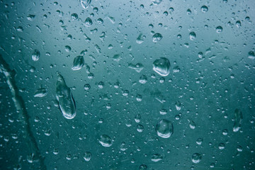 water droplets on translucent, misted glass. Spring rain drops on fogged window close up. blurred background copy space