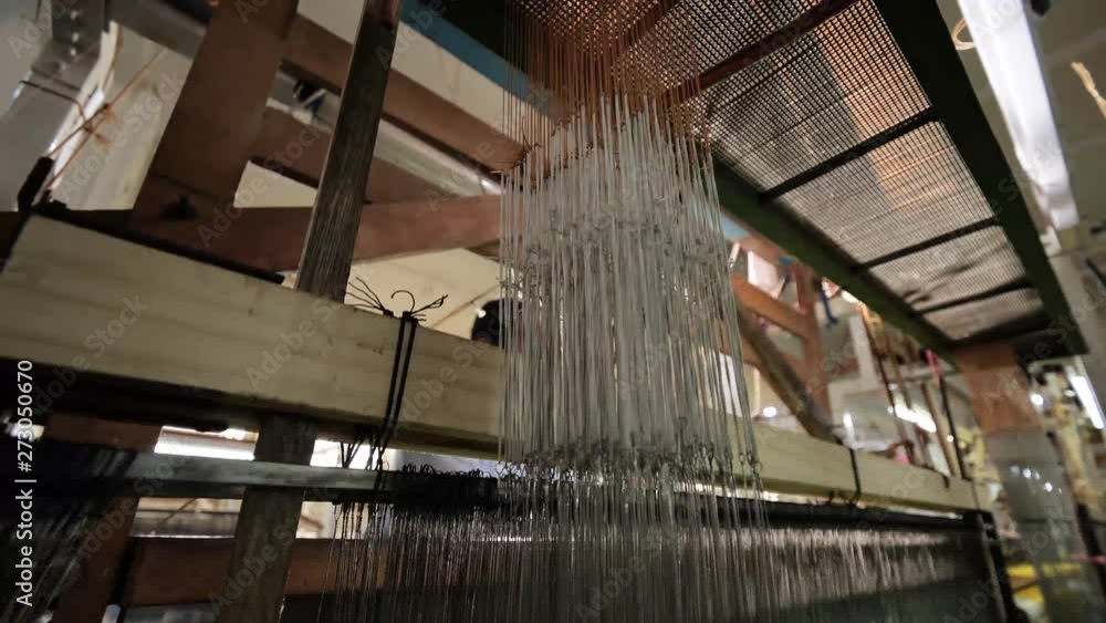 Poster worker operates a textile loom in the factory sequence shot