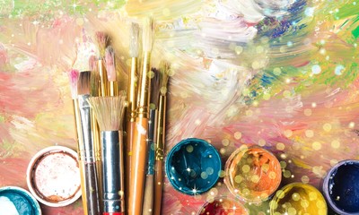 Fototapeta premium Artist paint brushes and paint cans of paint over bright watercolor background