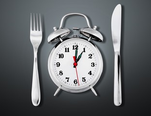 Alarm clock with knife and fork  for mealtime or diet concept