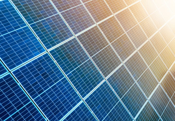 Close-up surface of lit by sun blue shiny solar photo voltaic panels. System producing renewable...