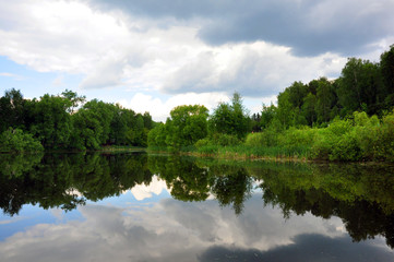 Colorful nature scenic photo of transparent aquamarine blue water surface of a lake with forest.