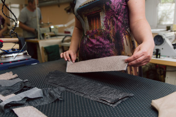 A woman strokes the fabric for further sewing. Tailor ironing clothes