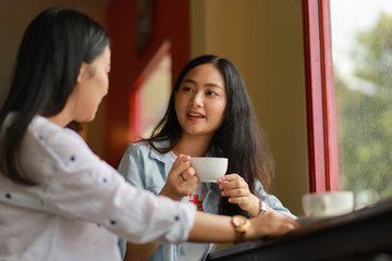Asian woman using  laptop working and drink coffee in cafe
