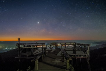 Mountain view morning at night of wooden terrace view point under the stars and Zodiacal light in the sky background, Doi Ang Khang, Chiang Mai, Thailand. Thai Text means Monzone View Point.