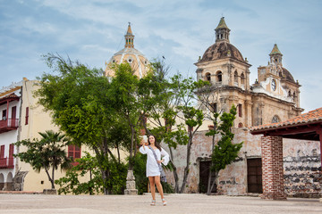 Beautiful woman taking selfies at the walls surrounding the colonial city of Cartagena de Indias