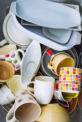 Heap of different crockery, porcelain and ceramic dishes. Bowl, plates and cups. Close up
