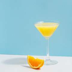 Fruit berry drink in a glass with ice on a colored background.