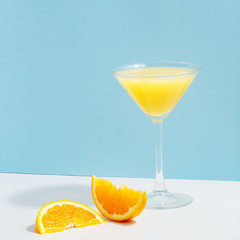 Fruit berry drink in a glass with ice on a colored background.