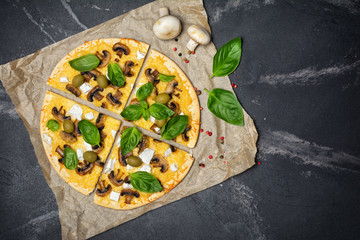 Pizza with mushrooms, cheese, olives and basil