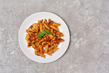 Penne pasta in tomato sauce with basil leaves