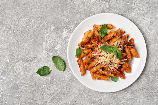 Penne pasta in tomato sauce with parmesan cheese and basil