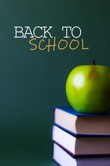 An apple on the book and next to the inscription back to school.