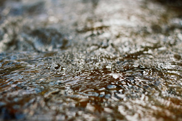 Close-up of bright blue flowing water stream of mountain river. Atmospheric dynamic background