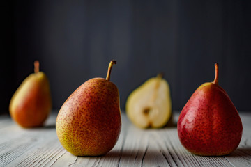 PEARS ON THE WHITE WOODEN COUNTER TOP GRAY WOODEN BLURRED BACKGROUND