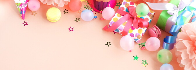 Banner party background top view.  Festive , birthday multicolored decorations on coral color background . Flat lay style. Copy space