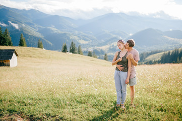 Fototapeta na wymiar Lifestyle loving couple hugging at nature among mountains in summer.