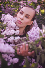 Fototapeta premium Young beautiful woman with fantasy make up posing with lilac flowers