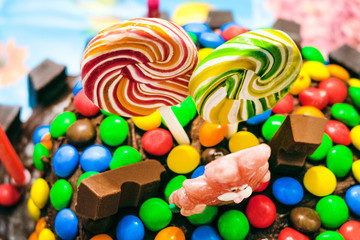 Fototapeta na wymiar Colored lollipops and chocolate dragees in the glaze. Sweet candies. Selective focus and limited depth of field.