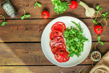 salad with tomatoes, arugula, balsamic sauce (fresh vegetables and salad dressing). Top view. copy space