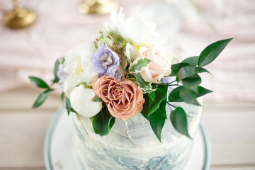 Close-up sweet rustic cake with fresh berries and flowers on wooden background
