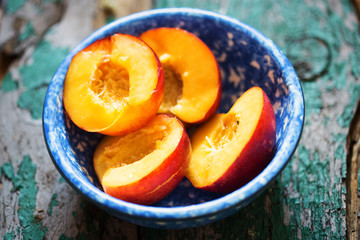 Cut nectarines fruits  in blue bowl 