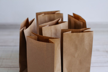 Paper bags on light wooden floor. Simple brown paper bags for lunch or meal. The layout for the...