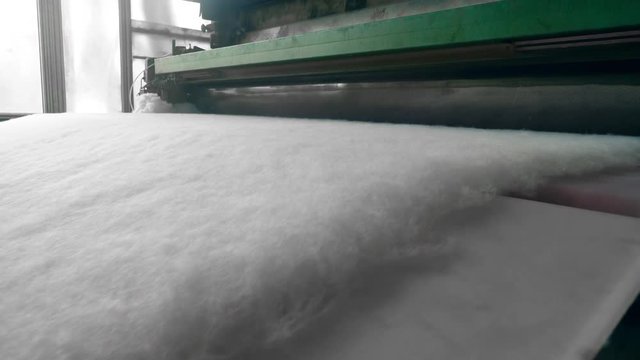 Rolling machine works with polyester material at a factory.