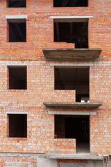 Unfinished brick building with many window and balcony