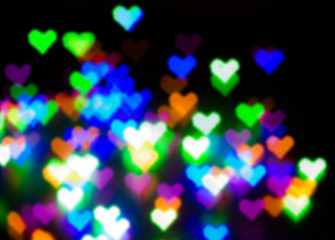 Blurred festive background with defocused colourful glitter formed a heart, bokeh in a shape of a heart. Original photographic effect. Pictures concept theme Love and St. Valentine's Day