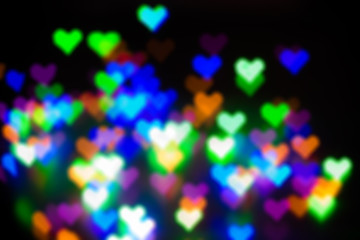 Blurred festive background with defocused colourful glitter formed a heart, bokeh in a shape of a heart. Original photographic effect. Pictures concept theme Love and St. Valentine's Day