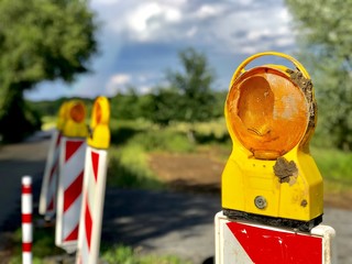 Outdoor sunny view of road construction in countryside concept. Close up yellow and orange...