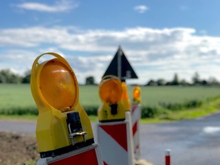 Outdoor sunny view of road construction in countryside concept. Close up yellow and orange...