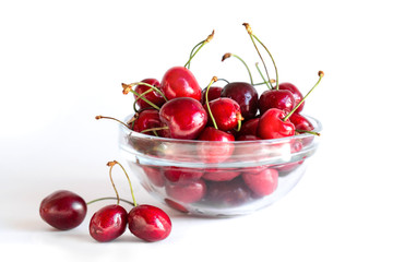 Sweet cherry in a glass plate on a white background. Juicy, tasty fruits.