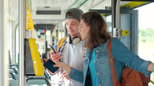 Man and women tourist using phone buy tickets in public transport