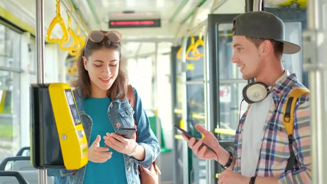 Girl halping male tourist buy tickets in public transport
