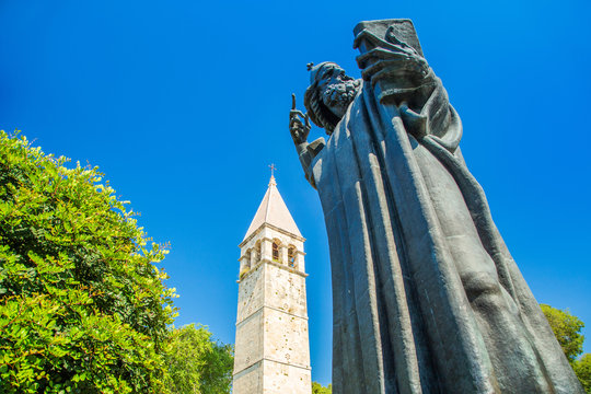 Split, Croatia, memorial stature of bischop Grgur Ninski and bell tower of St. Arnir and benedictine monastery in beautiful classic park