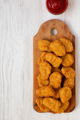 Chicken nuggets with ketchup on a white wooden background, top view. Flat lay, from above, overhead. Copy space.